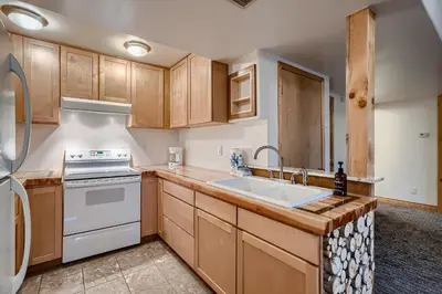 a kitchen with wooden cabinets and a white stove top oven at Mountain View Retreat home in Nederland