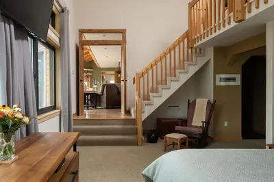 a room with a bed and a stairway at Lookout Lodge in Wondervu home in Nederland