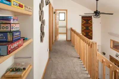 a hallway with a staircase and a room with shelves at Lookout Lodge in Wondervu home in Nederland
