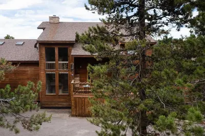 a log home with a porch and a deck at Lookout Lodge in Wondervu home in Nederland