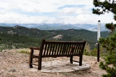 a wooden bench sitting on top of a mountain at Lookout Lodge in Wondervu home in Nederland