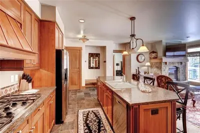 a large kitchen with wooden cabinets and a large island at Ski In, Ski Out 3 Bedroom At Lone Eagle In River Run in Dillon
