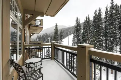a balcony with chairs and a view of a snow covered mountain at Ski In, Ski Out 3 Bedroom At Lone Eagle In River Run in Dillon