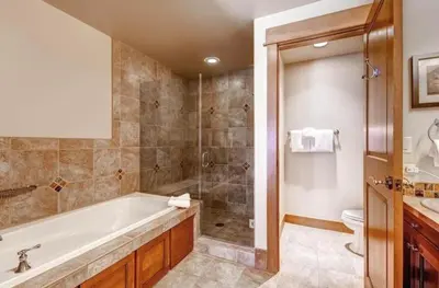 a bathroom with a tub and a shower and a toilet at Ski In, Ski Out 3 Bedroom At Lone Eagle In River Run in Dillon