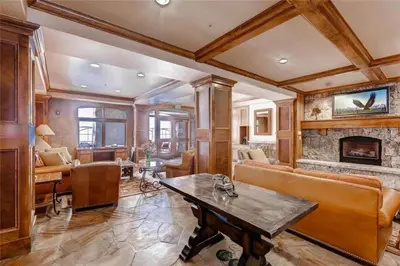 a living room with a table and a fireplace at Ski In, Ski Out 3 Bedroom At Lone Eagle In River Run in Dillon