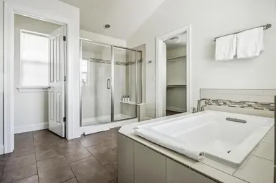a white bathroom with a tub and a shower at Modern Elegance - Pool Table - Walkable Area in Aurora