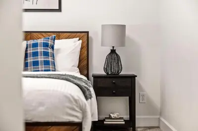 a bedroom with a bed and a lamp on a nightstand at Modern Elegance - Pool Table - Walkable Area in Aurora
