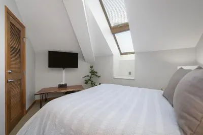 a bedroom with a white bed and a television at Select Unit 1709 - 2BR - Zephyr Mountain Lodge condo in Winter Park