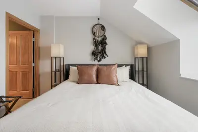 a bedroom with a bed with a clock on the wall at Select Unit 1709 - 2BR - Zephyr Mountain Lodge condo in Winter Park