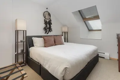 a bedroom with a large bed with a clock on the wall at Select Unit 1709 - 2BR - Zephyr Mountain Lodge condo in Winter Park