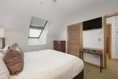 a bedroom with a large bed and a television at Select Unit 1709 - 2BR - Zephyr Mountain Lodge condo in Winter Park