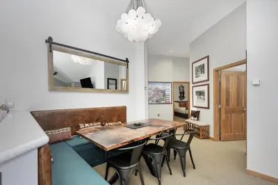 a dining room with a table and chairs and a mirror at Select Unit 1709 - 2BR - Zephyr Mountain Lodge condo in Winter Park