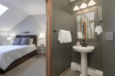 a bedroom with a bed and a sink and a mirror at Select Unit 1709 - 2BR - Zephyr Mountain Lodge condo in Winter Park