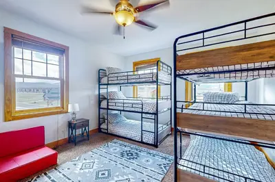 a room with three bunk beds and a ceiling fan at Mountain Sky Retreat in Granby