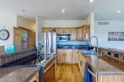 a kitchen with wooden cabinets and a stainless steel refrigerator at Mountain Sky Retreat in Granby