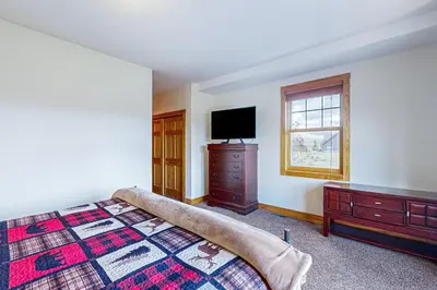 a bedroom with a bed and a dresser and a television at Mountain Sky Retreat in Granby