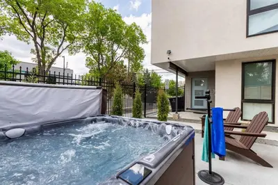 a hot tub on the patio of a house with a bench at LuxuryDenver Studio w Hot Tub 2 Mi to Downtown in Denver