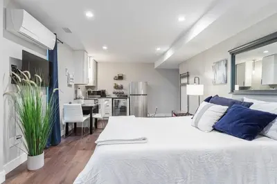 a bedroom with a large white bed with blue pillows at LuxuryDenver Studio w Hot Tub 2 Mi to Downtown in Denver