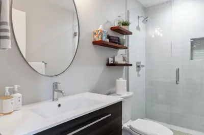 a bathroom with a sink and a mirror and a toilet at LuxuryDenver Studio w Hot Tub 2 Mi to Downtown in Denver