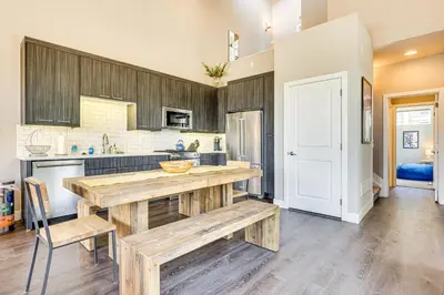 a kitchen with wooden cabinets and a table and chairs at Walk to Dtwn Fraser Retreat with Hot Tub and Views! in Winter Park