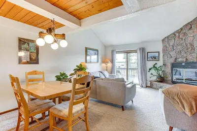 a dining room and living room with a table and a fireplace at Fraser Mountain Retreat with Resort Amenities! in Fraser