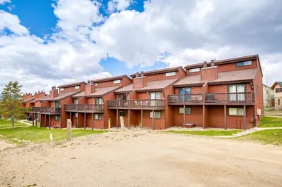 an apartment building with balconies on a dirt road at Fraser Mountain Retreat with Resort Amenities! in Fraser