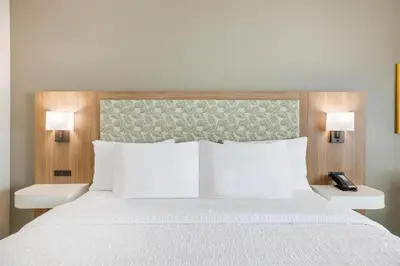 a bedroom with a white bed with two lamps at Hampton Inn Aurora Medical Center Denver in Aurora