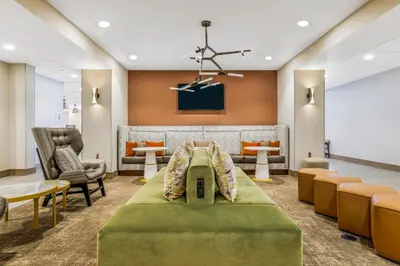 a waiting room at a hospital with a bed and chairs at Hampton Inn Aurora Medical Center Denver in Aurora