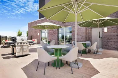 a patio with a table and chairs and umbrellas at Hampton Inn Aurora Medical Center Denver in Aurora