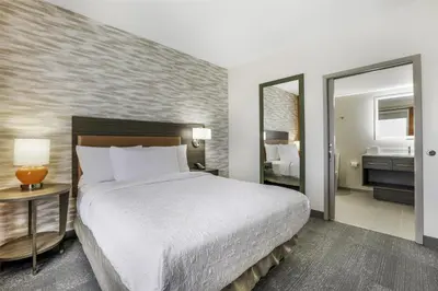 a hotel room with a large bed and a mirror at Home2 Suites By Hilton Aurora Medical Center Denver in Aurora