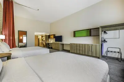 a hotel room with two beds and a television at Home2 Suites By Hilton Aurora Medical Center Denver in Aurora