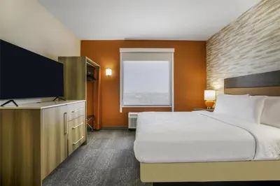 a hotel room with a bed and a flat screen tv at Home2 Suites By Hilton Aurora Medical Center Denver in Aurora