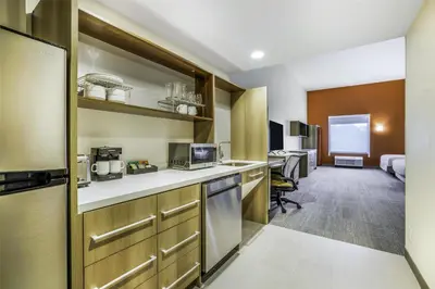 a hotel room with a kitchen and a bedroom at Home2 Suites By Hilton Aurora Medical Center Denver in Aurora