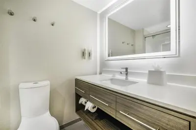 a white bathroom with a sink and a mirror at Home2 Suites By Hilton Aurora Medical Center Denver in Aurora