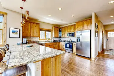 a kitchen with wooden cabinets and a marble counter top at Winter Park Ski & Summer Retreat in Fraser