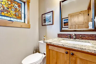 a bathroom with a toilet and a sink and a mirror at Winter Park Ski & Summer Retreat in Fraser