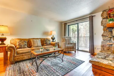 a living room with a couch and a table at Winter Park Condo with Resort Shuttle On-Site! in Winter Park