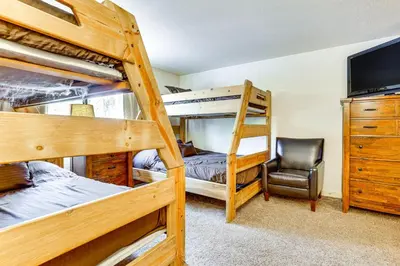 a bedroom with two bunk beds and a chair at Winter Park Condo with Resort Shuttle On-Site! in Winter Park