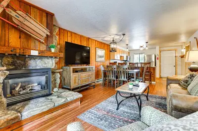 a living room with a fireplace and a table at Winter Park Condo with Resort Shuttle On-Site! in Winter Park