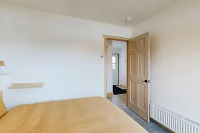 a bedroom with a bed and an open door at Hytta Hyggelig in Tabernash