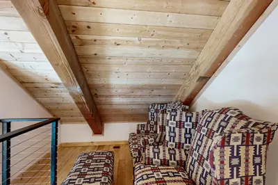 a living room with two couches and wooden ceilings at Hytta Hyggelig in Tabernash