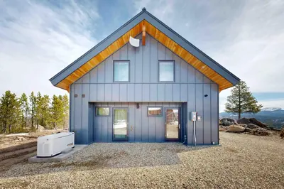 a house with blue doors and a air conditioner at Hytta Hyggelig in Tabernash