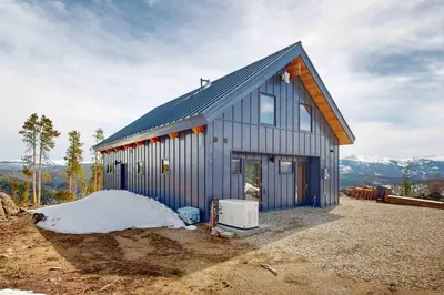 a small blue house with a snow pile at Hytta Hyggelig in Tabernash