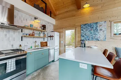 a kitchen with blue cabinets and a white refrigerator at Hytta Hyggelig in Tabernash