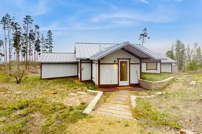 a small house in the middle of a field at Mountain Minka in Grand Lake