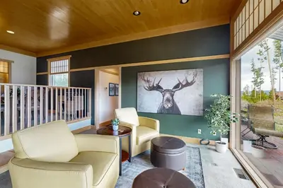 a living room with two chairs and a painting of a deer on the wall at Mountain Minka in Grand Lake