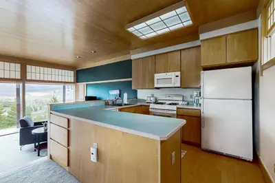 a kitchen with wooden cabinets and a white refrigerator at Mountain Minka in Grand Lake