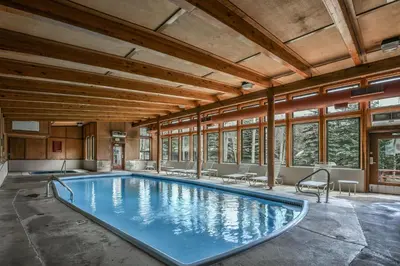 a large swimming pool in a building with windows at 2024 Homestead condo in Keystone