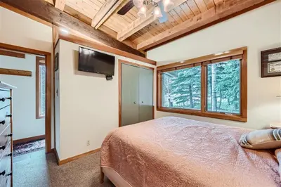 a bedroom with a bed and a flat screen tv at 2024 Homestead condo in Keystone