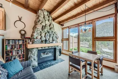 a living room with a fireplace and a table and chairs at 2024 Homestead condo in Keystone